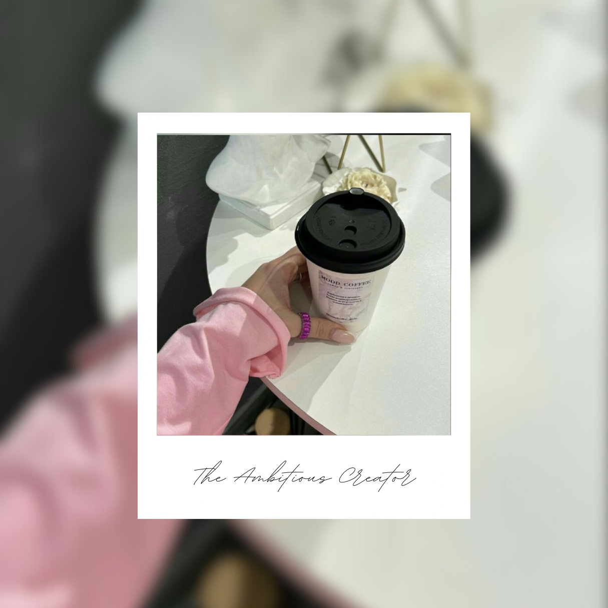 A woman with a pink shirt holding her coffee cup on a white table