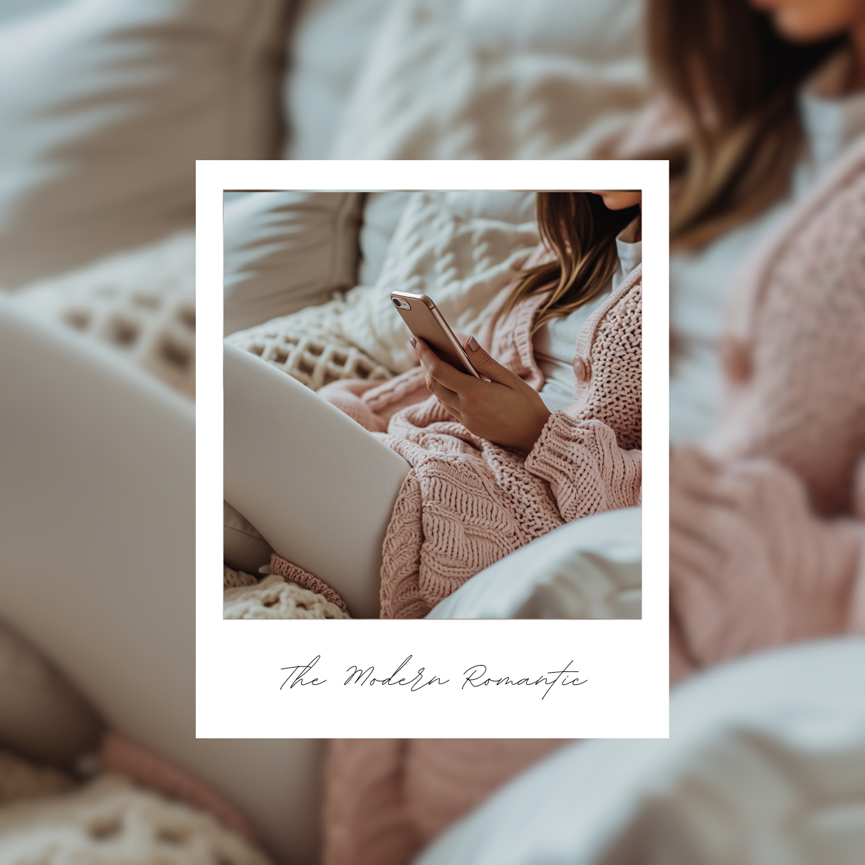 A modern romantic woman on her phone sitting on a cozy lounge in a pink cardigan 